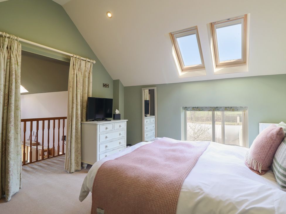 A bedroom with a bed and television at Ystwyth Cottage Newtown