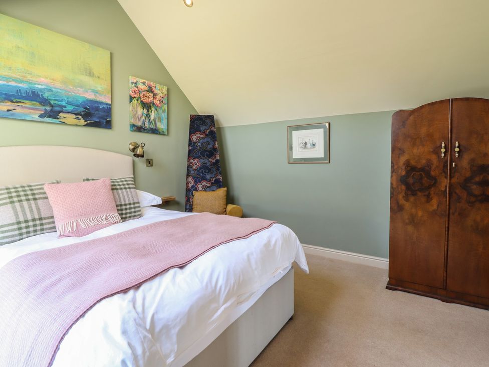 A bedroom with a bed and wardrobe at Ystwyth Cottage Newtown