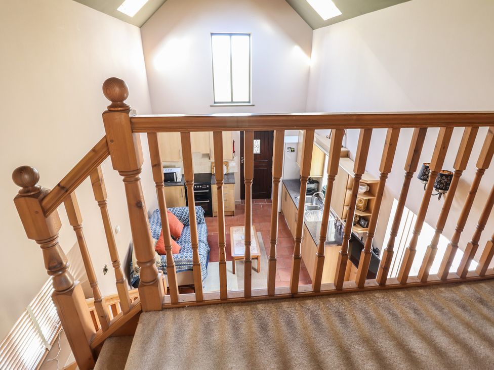 A living room view from above with a sofa and kitchen area at Ystwyth Cottage Newtown