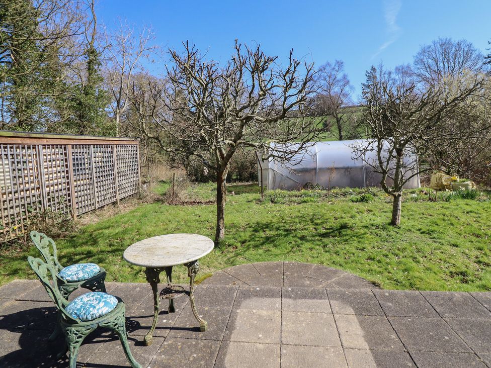 A garden with a table and chairs at Ystwyth Cottage in Newtown