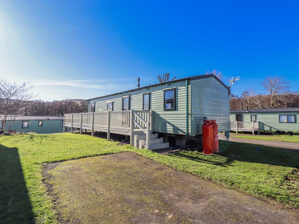 A mobile home with decking and gas cylinder at 75 Morpeth Mews Wooler