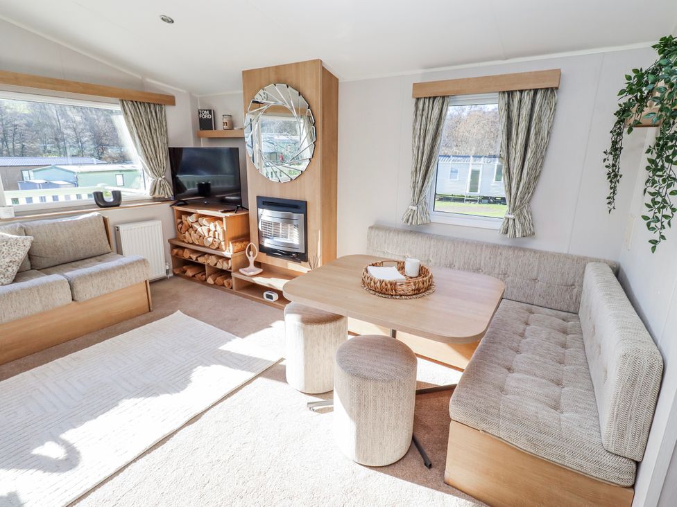 A living room with a sofa and a table at 75 Morpeth Mews in Wooler