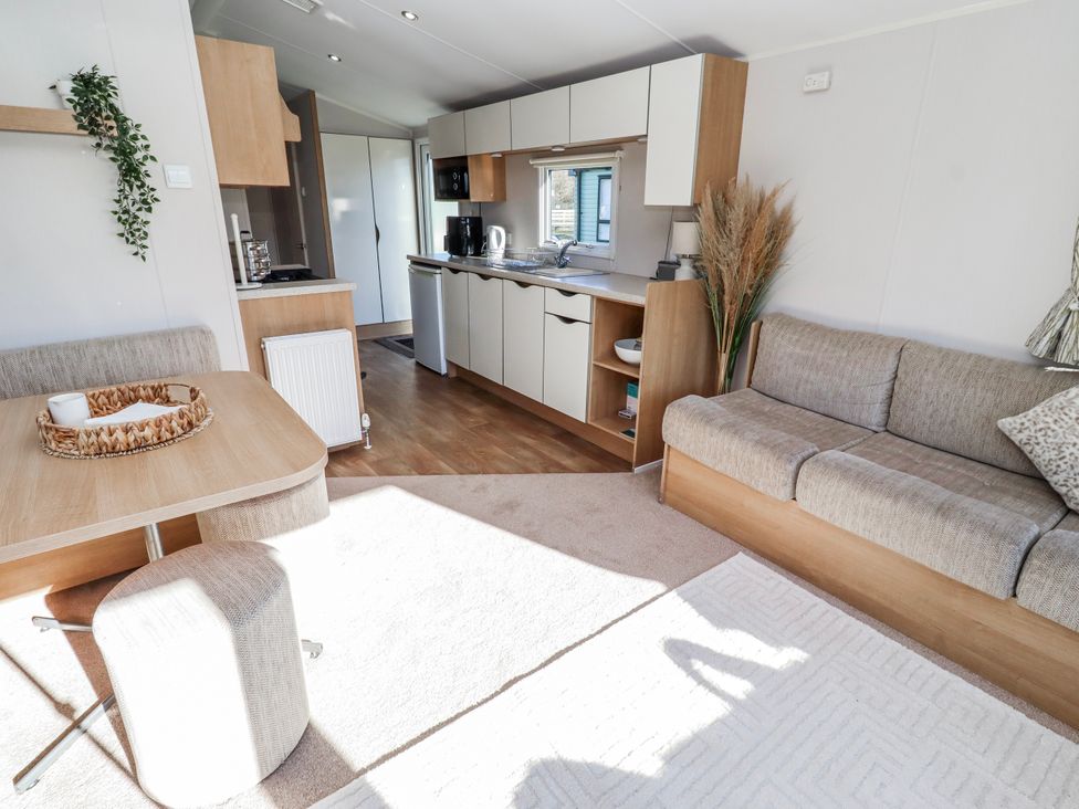 A living room with a sofa and table at 75 Morpeth Mews Wooler