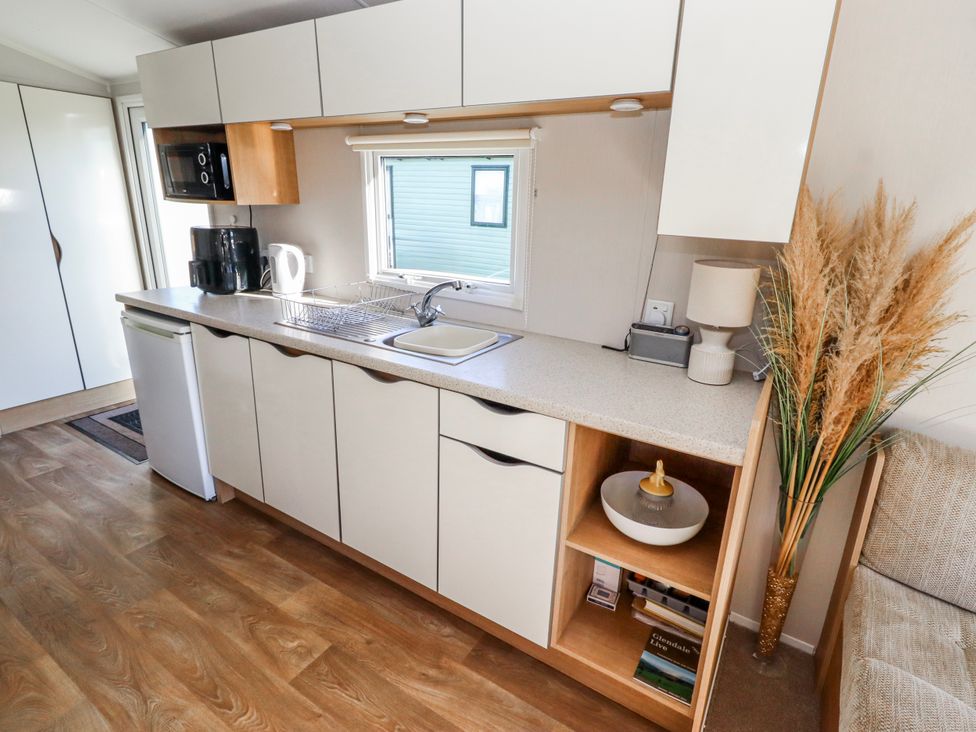 A kitchen with cabinets, sink, and appliances at 75 Morpeth Mews Wooler
