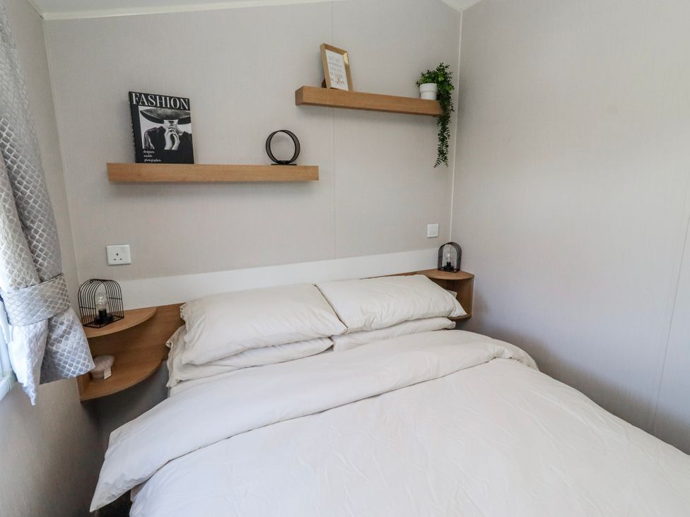 A bedroom with a bed and shelves at 75 Morpeth Mews Wooler