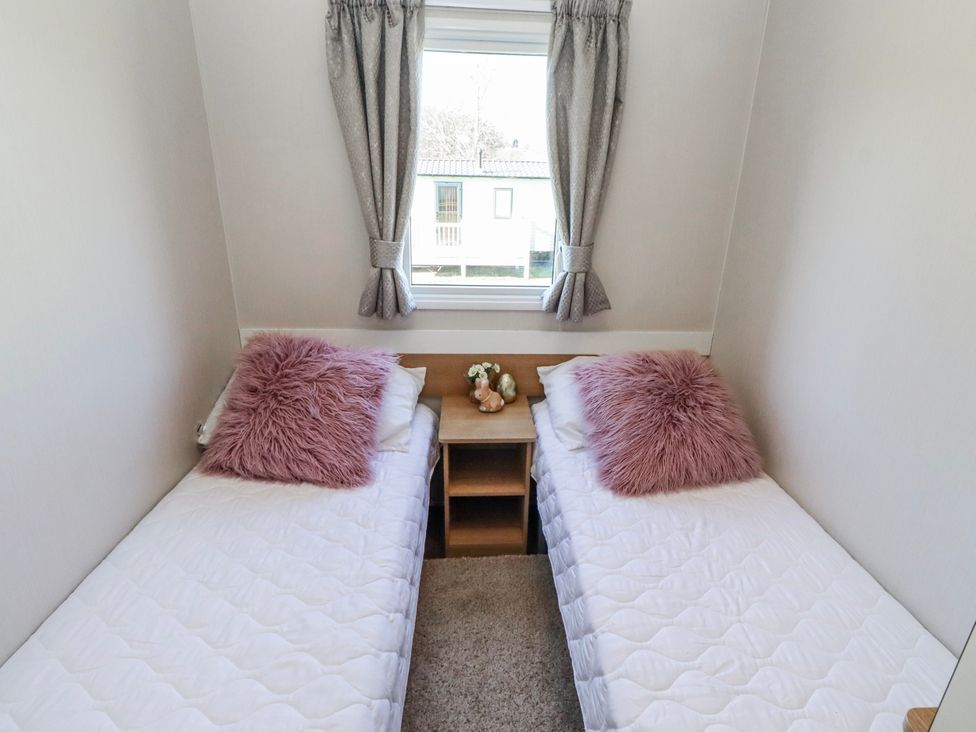 A bedroom with two single beds and a table at 75 Morpeth Mews Wooler