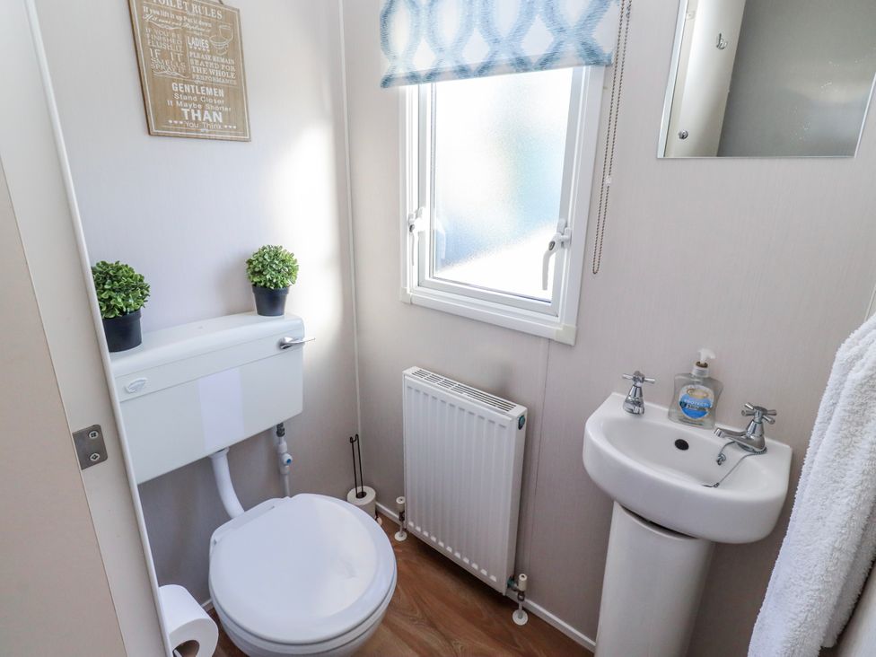 A bathroom with a toilet and sink at 75 Morpeth Mews in Wooler