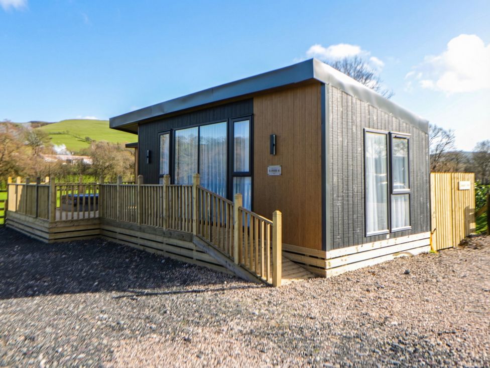 A cabin with a deck and fenced area at Dawn's Rest in Nantmel near Rhayader