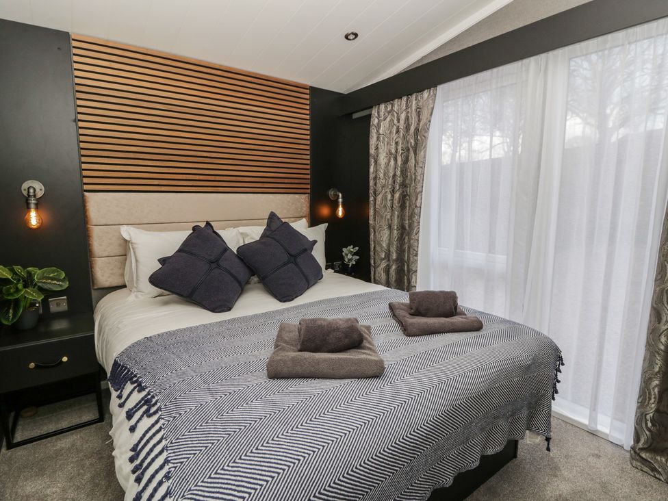 A bedroom with a bed and bedside table at Dawn's Rest Nantmel near Rhayader