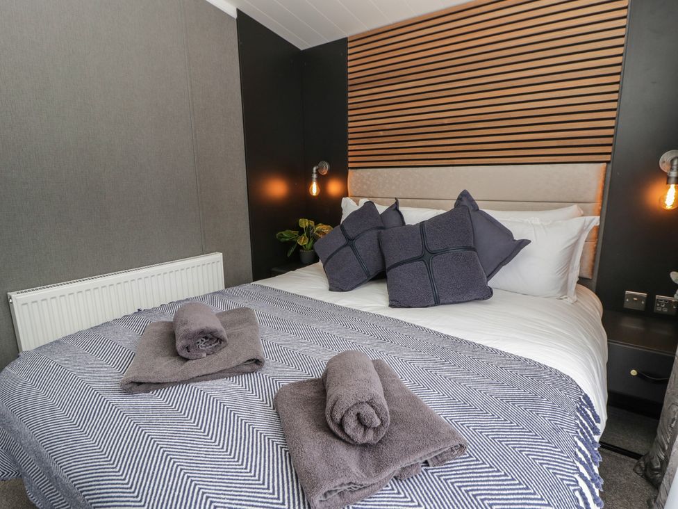 A bedroom with a bed and towels arranged on the bedding at Dawn's Rest Nantmel near Rhayader