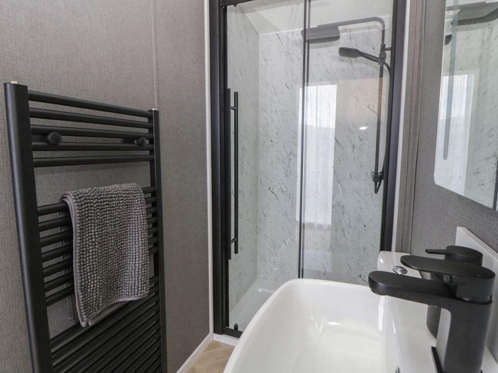 A bathroom with a shower and sink at Dawn's Rest Nantmel near Rhayader