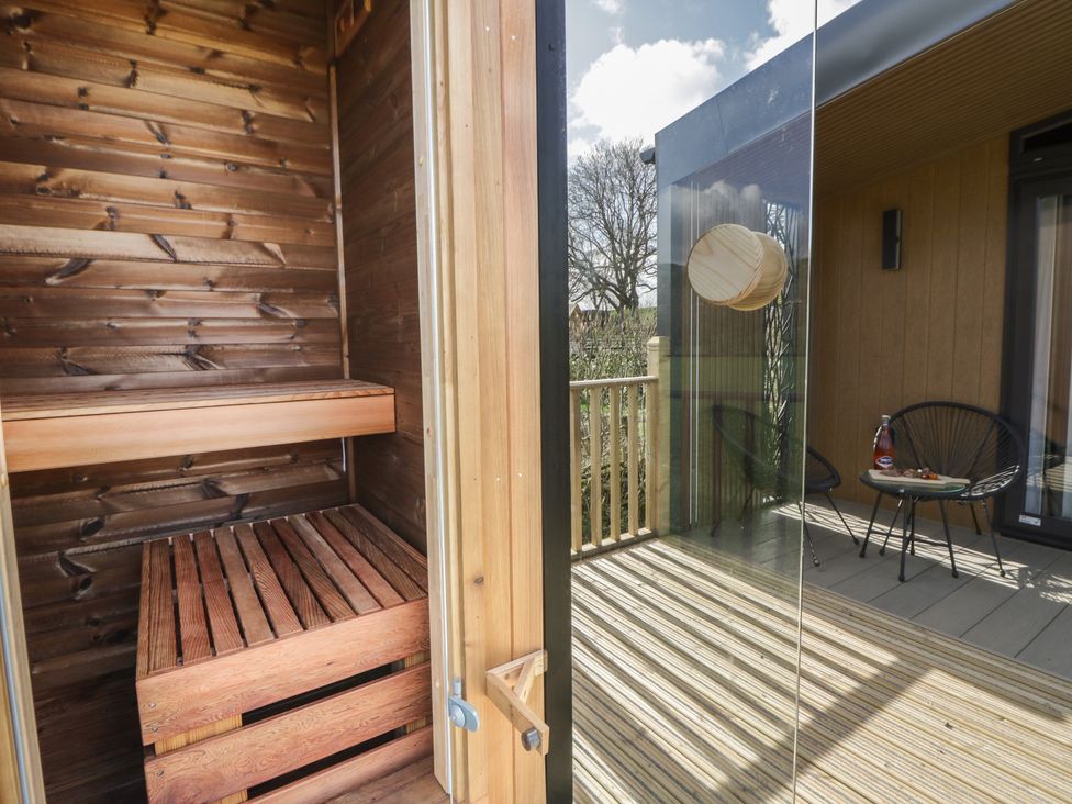 A sauna with wooden benches and a glass door at Dawn's Rest in Nantmel near Rhayader