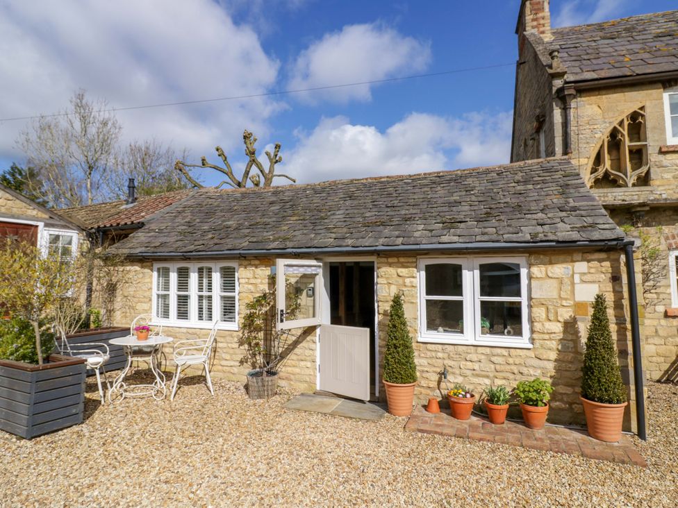 A cottage exterior with table and chairs at Halliday’s Cottages - The Cottage in Greetham near Cottesmore