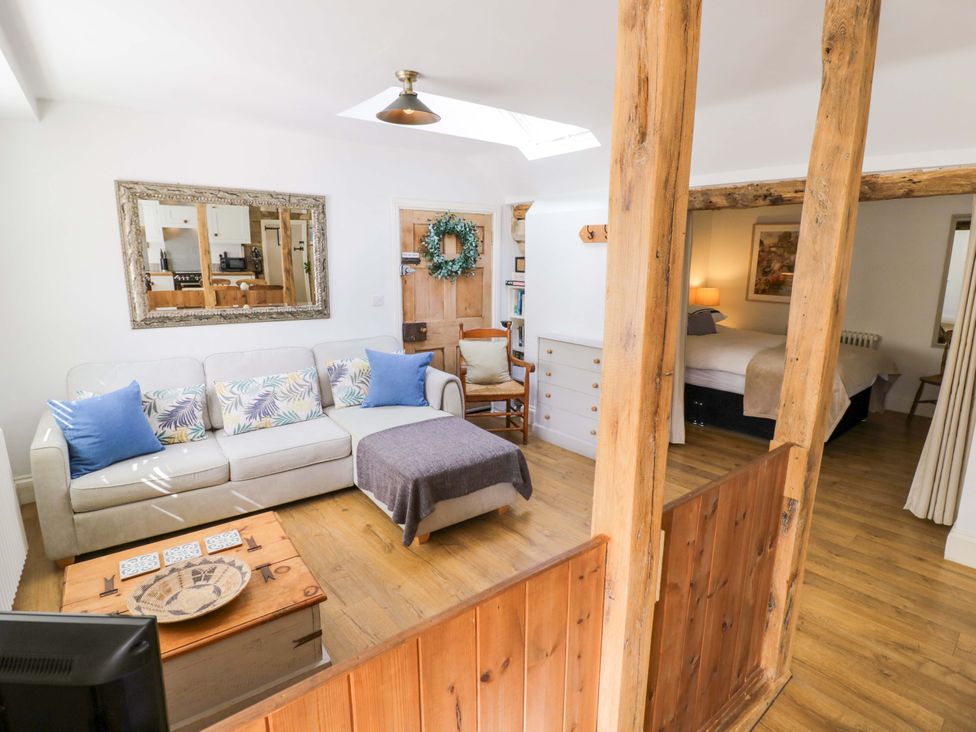 A living room with a sofa, coffee table, and doorway at Halliday’s Cottages - The Cottage in Greetham near Cottesmore