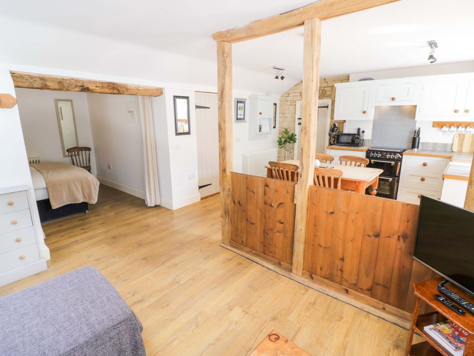 A living room with a wooden table and chairs at Halliday’s Cottages - The Cottage in Greetham near Cottesmore