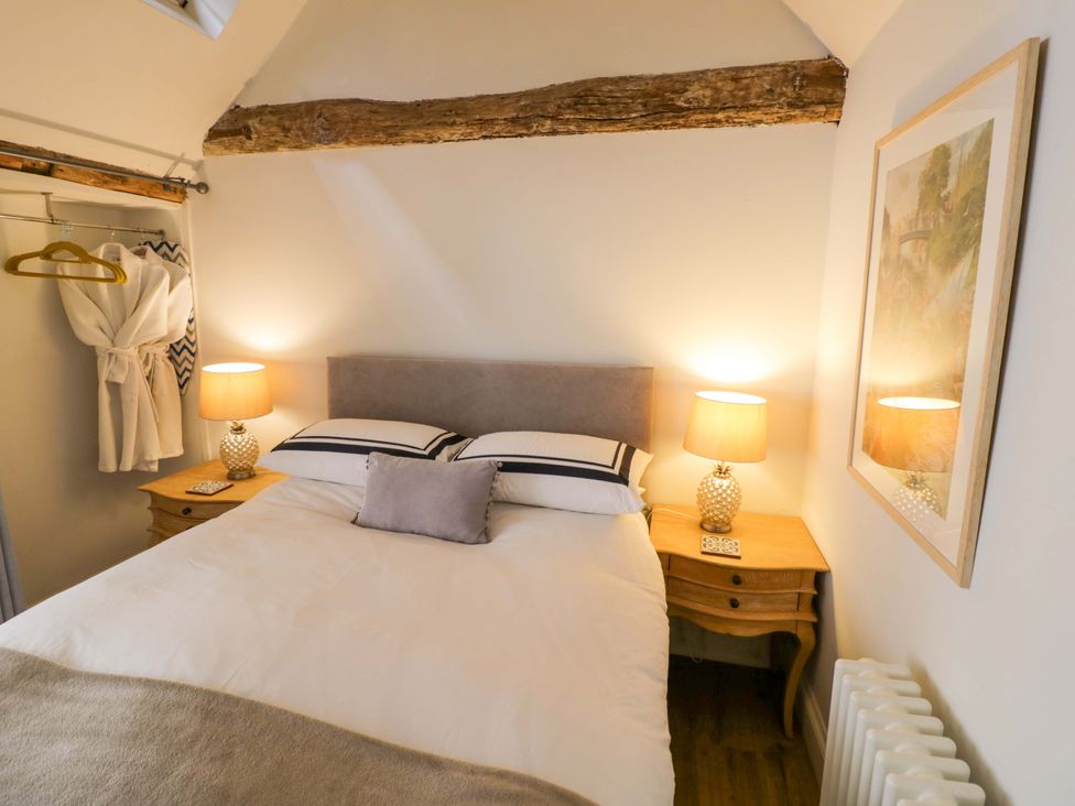 A bedroom with a bed and bedside tables at Halliday’s Cottages - The Cottage in Greetham near Cottesmore