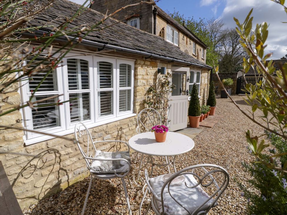 An outdoor seating area with a table and chairs at Halliday’s Cottages - The Cottage Greetham near Cottesmore