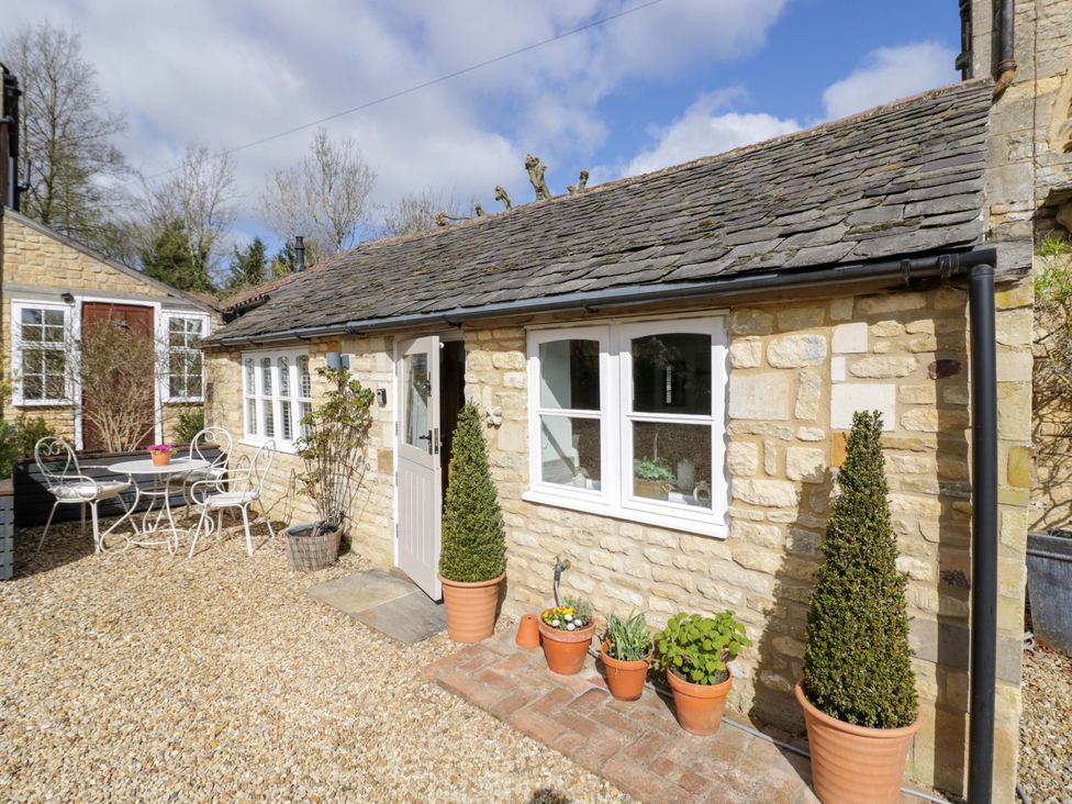 An outdoor area of a cottage with plants and seating at Halliday’s Cottages - The Cottage, Greetham near Cottesmore