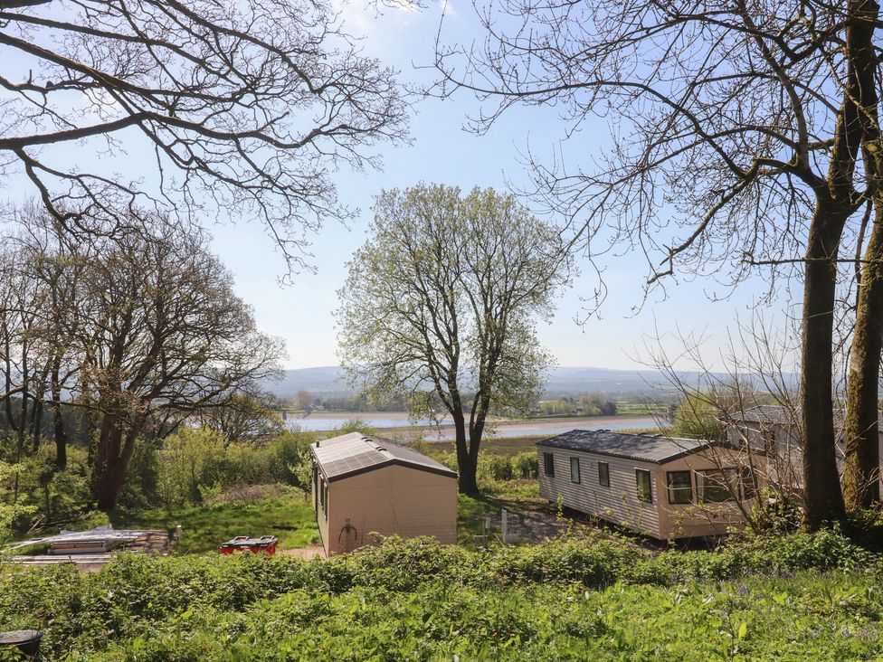 A view of trees and mobile homes with a river in the background at Beacon Fell Cottage 1 Preston