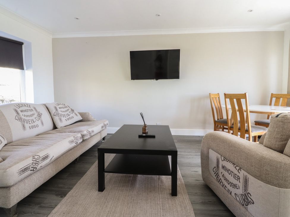 A living room with a sofa and dining area at Beacon Fell Cottage 1 Preston