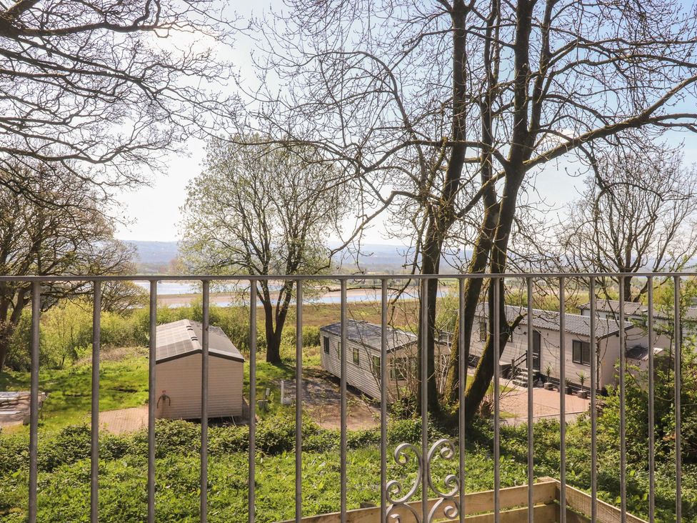 A view from a balcony showing trees and huts at Beacon Fell Cottage 1 Preston