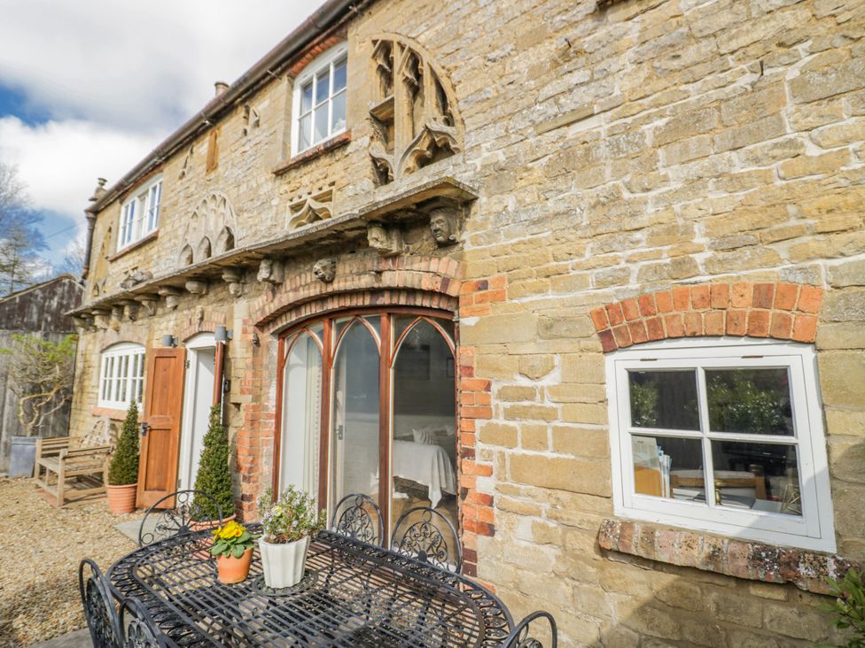 An outdoor view of a stone cottage with patio furniture at Halliday’s Cottages - The Folly Greetham near Cottesmore