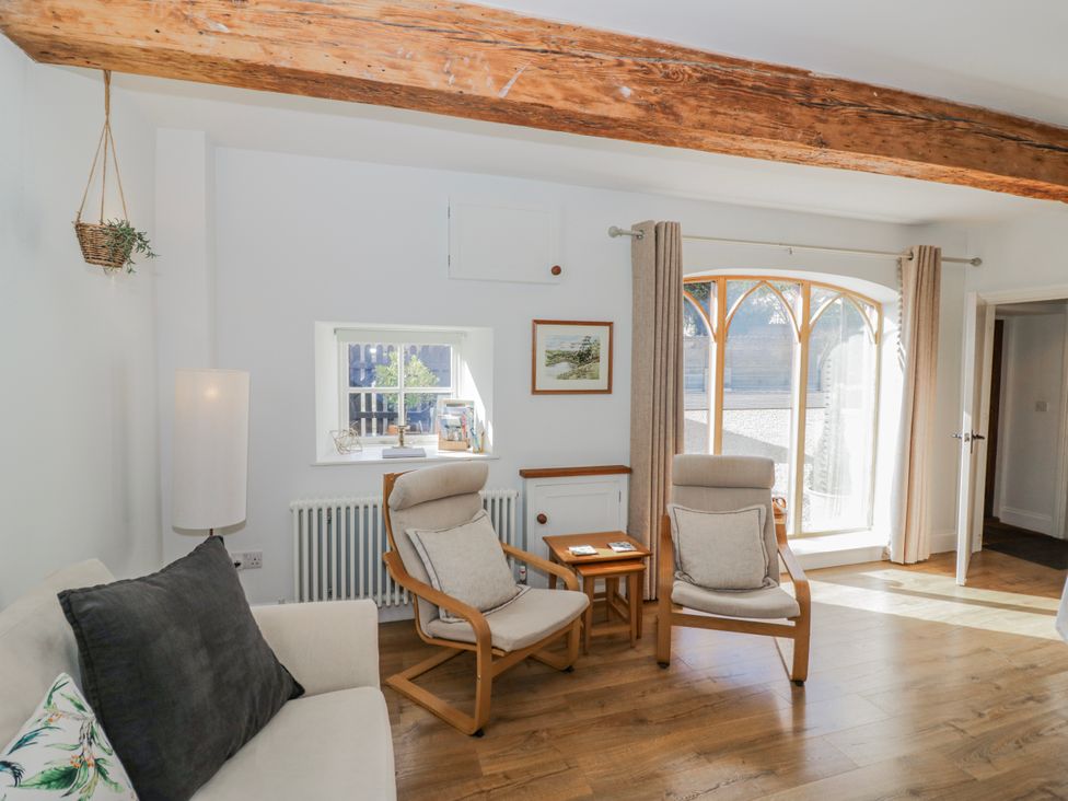 A living room with a sofa, chairs, and a window at Halliday’s Cottages - The Folly Greetham near Cottesmore