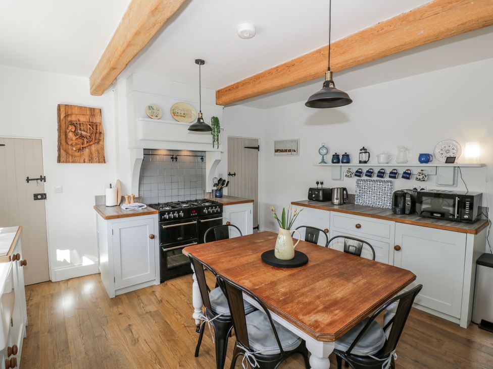 A kitchen with a dining table and appliances at Halliday’s Cottages - The Folly Greetham near Cottesmore