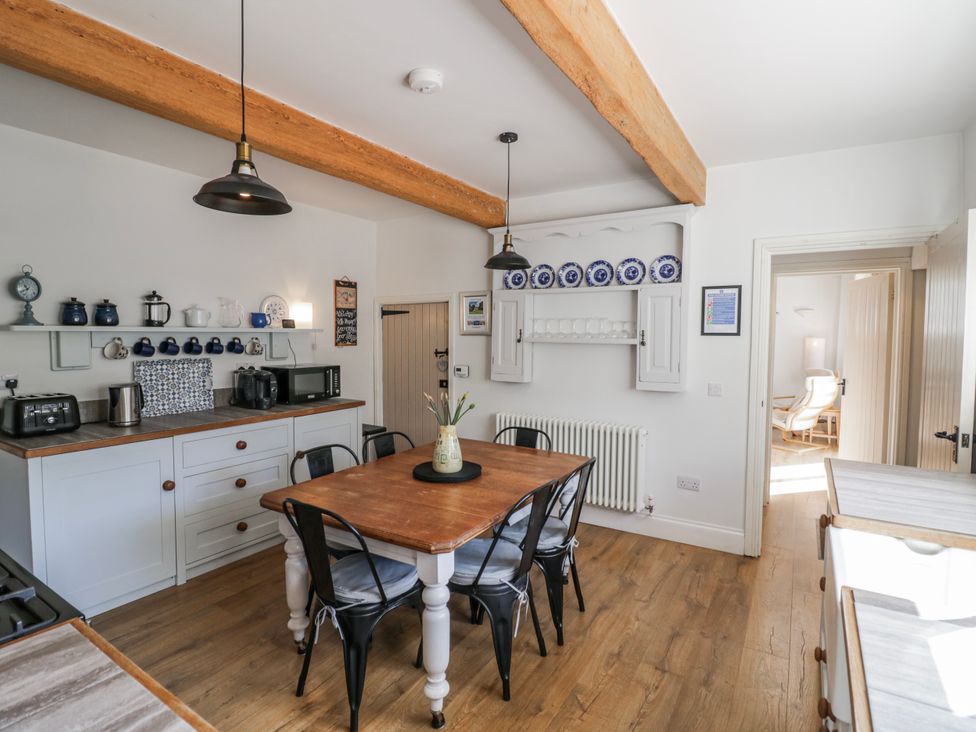 A kitchen with a dining table and chairs at Halliday’s Cottages - The Folly, Greetham near Cottesmore