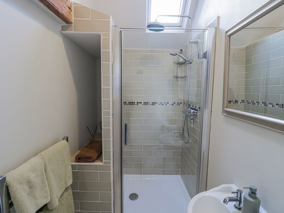 A bathroom with a shower and sink at Halliday’s Cottages - The Folly in Greetham near Cottesmore