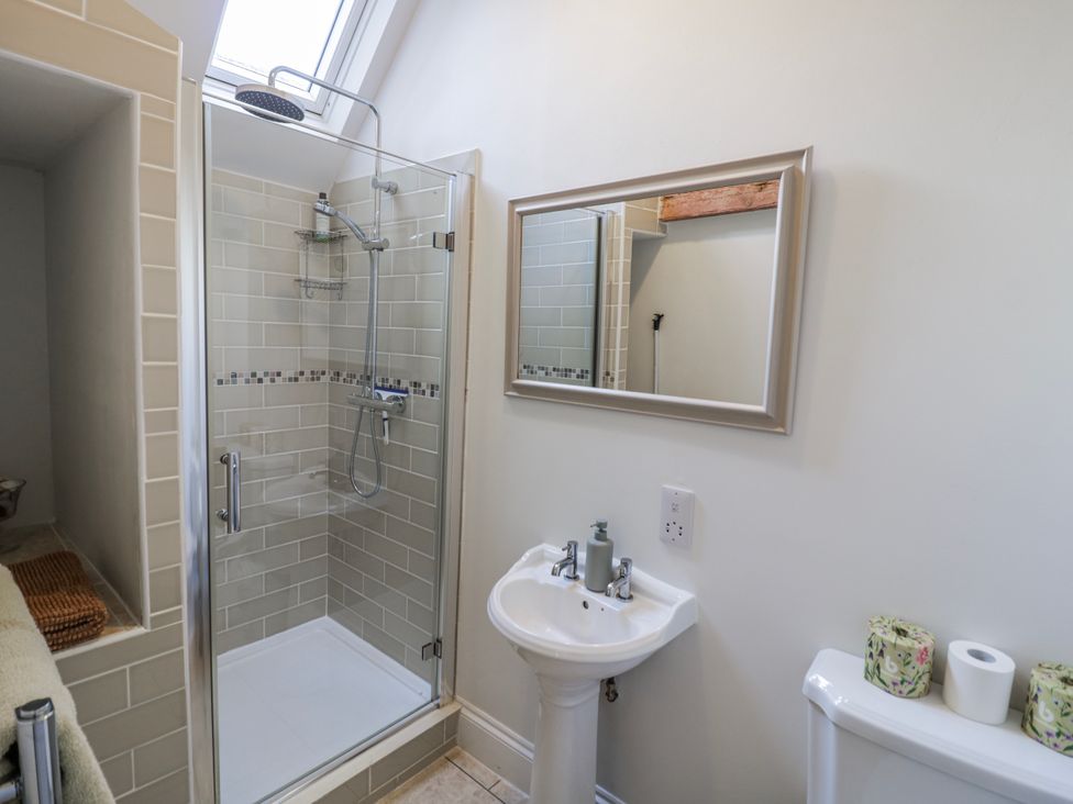 A bathroom with a shower, sink, and toilet at Halliday’s Cottages - The Folly in Greetham near Cottesmore