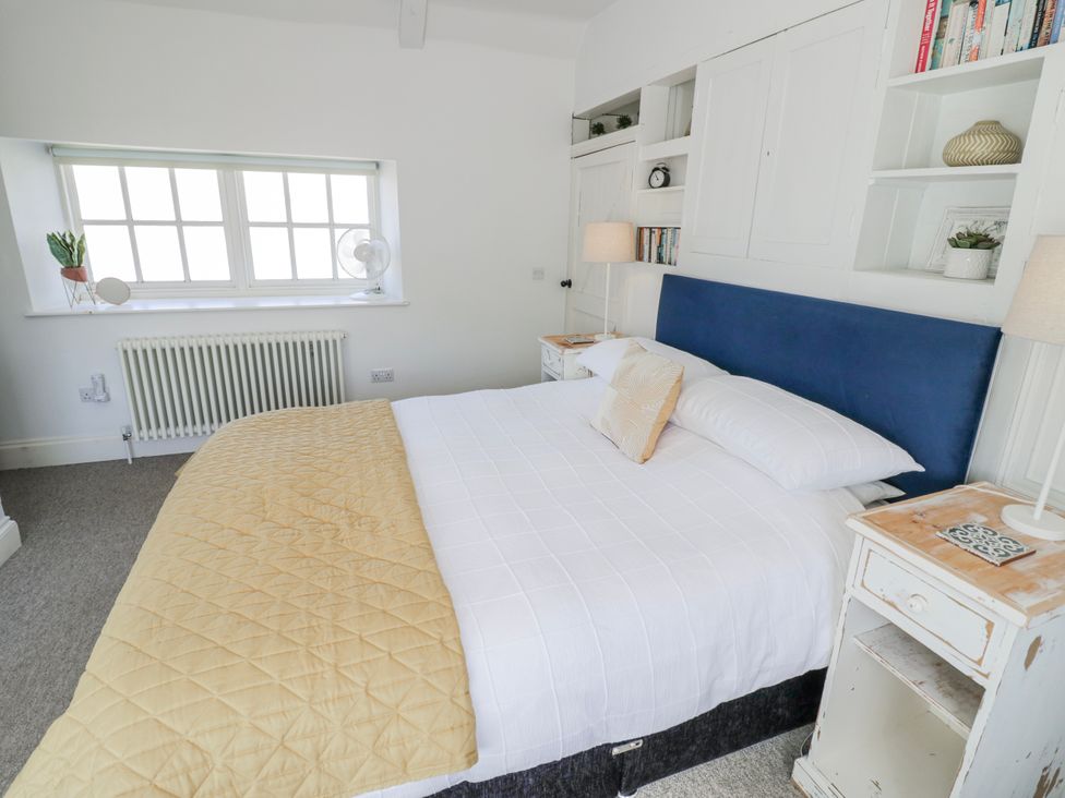 A bedroom with a bed and a bedside table at Halliday’s Cottages - The Folly in Greetham near Cottesmore