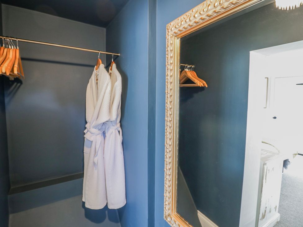 A dressing room with a robe and hangers at Halliday’s Cottages - The Folly in Greetham near Cottesmore