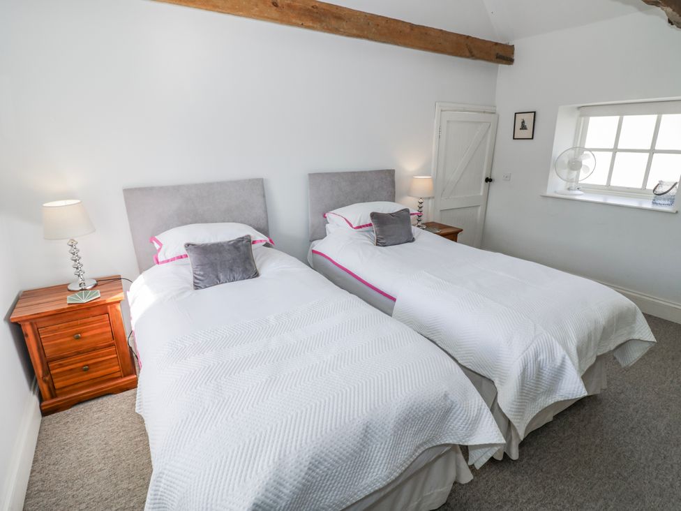 A bedroom with two single beds and a window at Halliday’s Cottages - The Folly, Greetham near Cottesmore