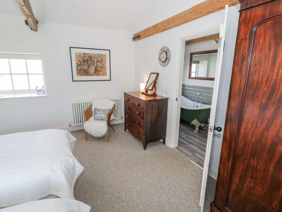 A bedroom with a bed and a dresser at Halliday’s Cottages - The Folly in Greetham near Cottesmore