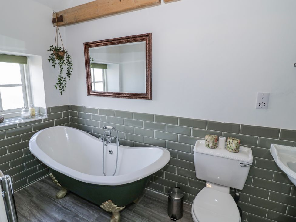 A bathroom with a bathtub and toilet at Halliday’s Cottages - The Folly in Greetham near Cottesmore