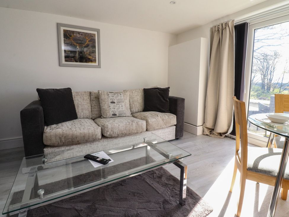 A living room with a sofa and a dining table at Beacon Fell Cottage 2 Longridge