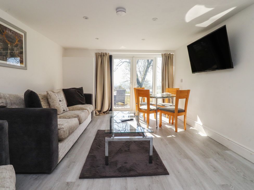 A living room with a sofa and dining area at Beacon Fell Cottage 2 Longridge
