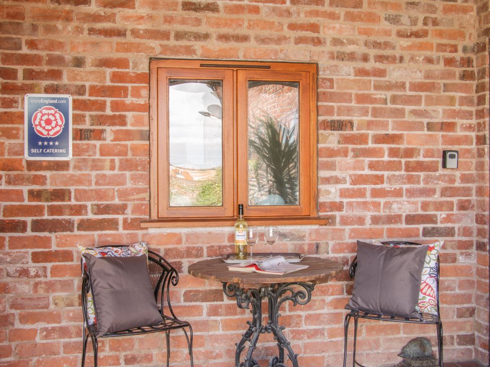 An outdoor seating area with a table and chairs at Herdwick Cottage in Much Wenlock