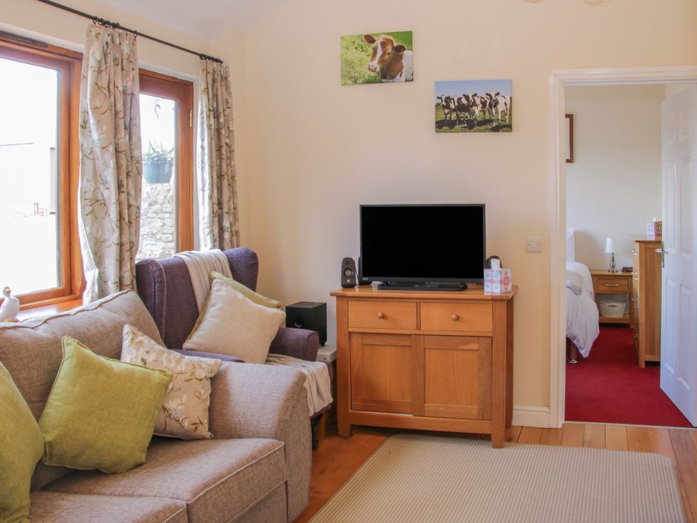 A living room with a sofa and television at Herdwick Cottage in Much Wenlock