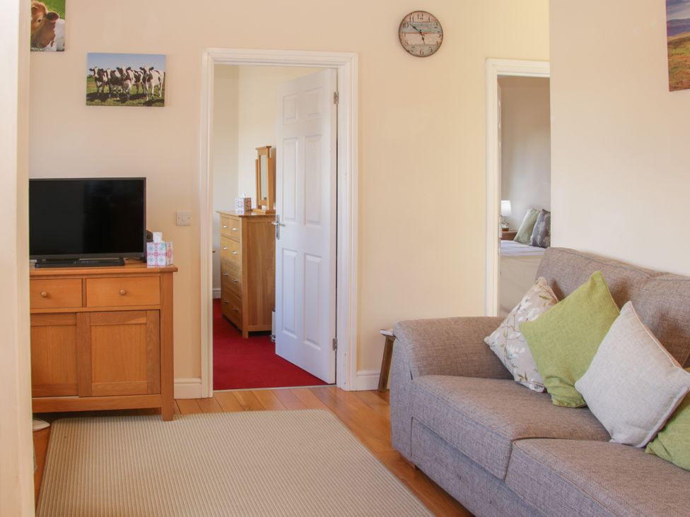 A living room with a sofa and television at Herdwick Cottage in Much Wenlock