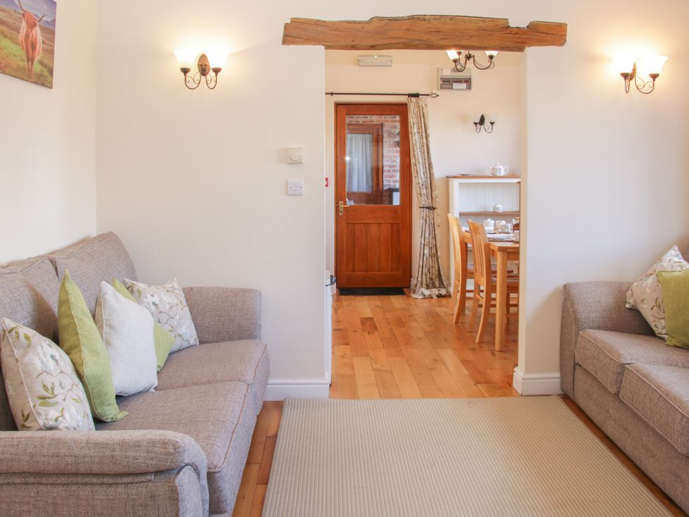 A living room with sofas and a dining area at Herdwick Cottage in Much Wenlock