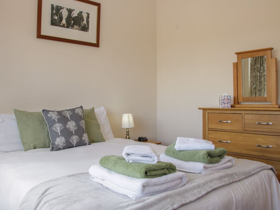 A bedroom with a bed and towels folded on top at Herdwick Cottage in Much Wenlock
