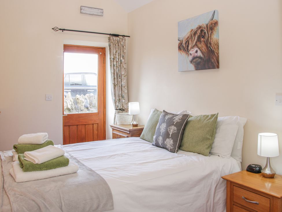 A bedroom with a bed and a door at Herdwick Cottage Much Wenlock