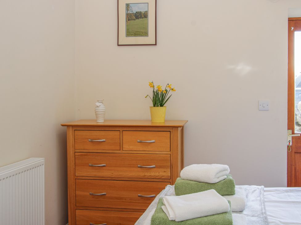 A bedroom with a dresser and towels at Herdwick Cottage in Much Wenlock