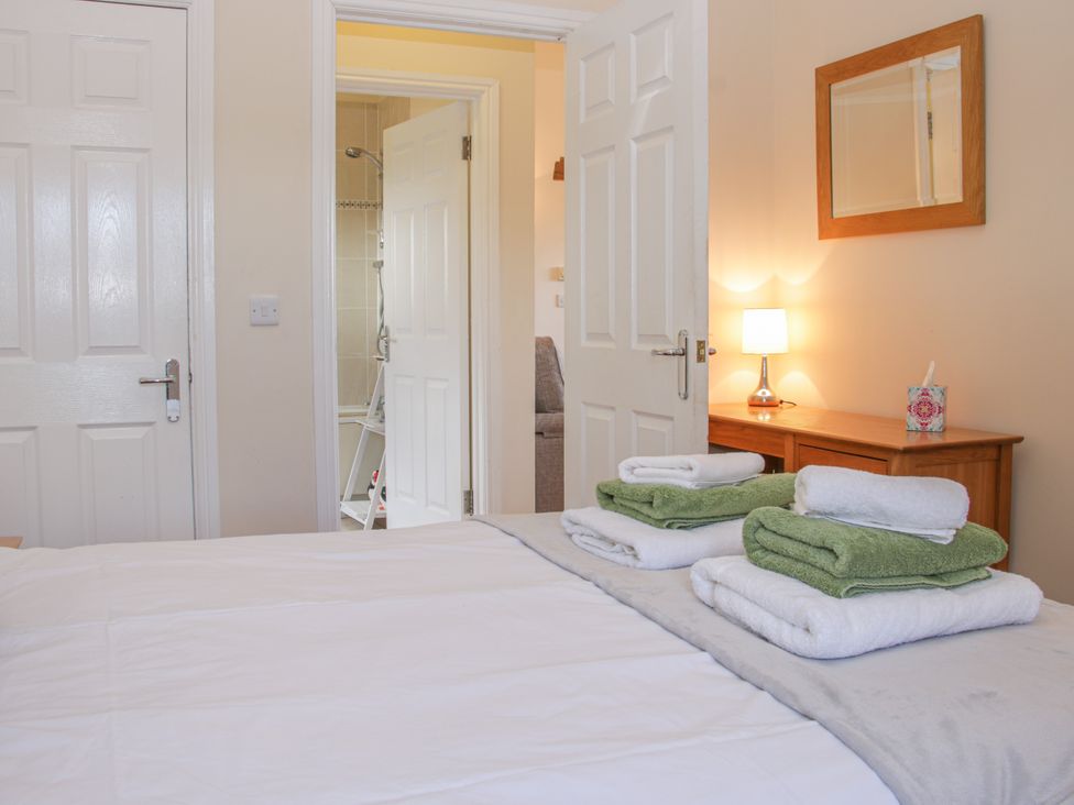 A bedroom with a bed and towels on it at Herdwick Cottage in Much Wenlock