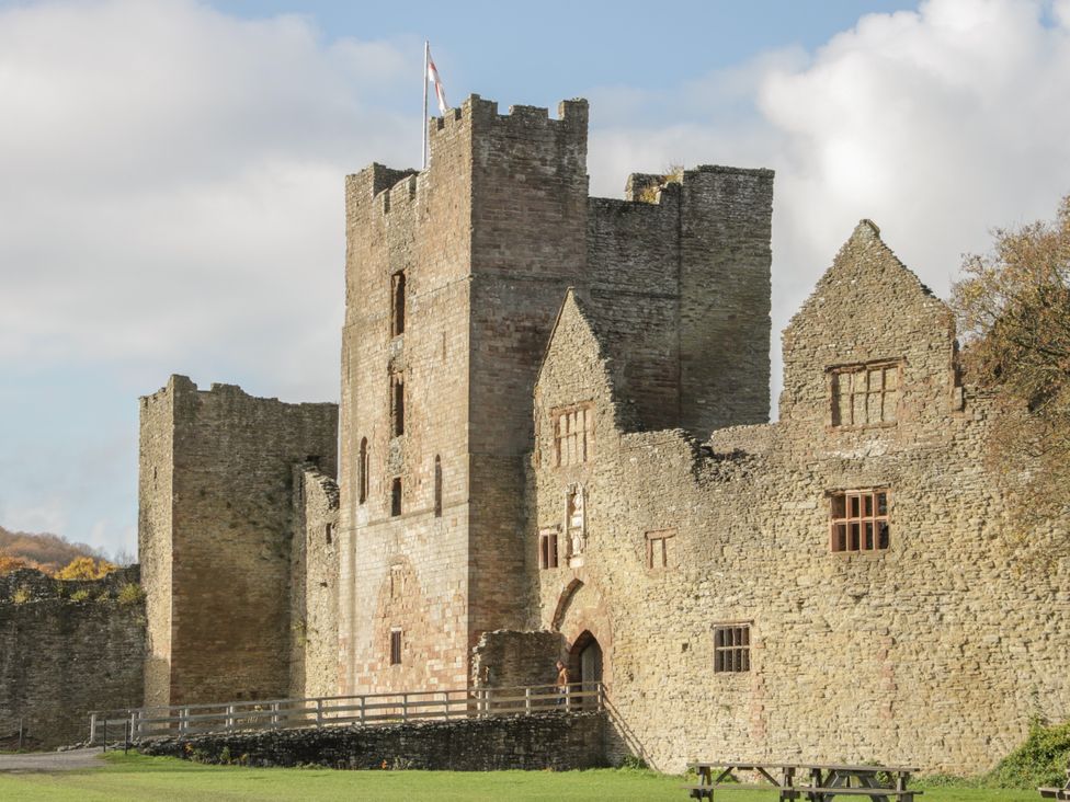 A castle with stone walls and towers at Herdwick Cottage in Much Wenlock