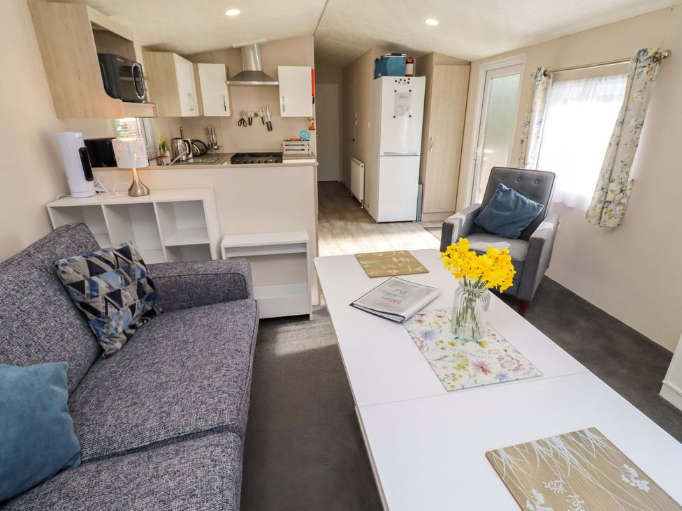 A living room with a sofa and coffee table at Gardeners Lodge