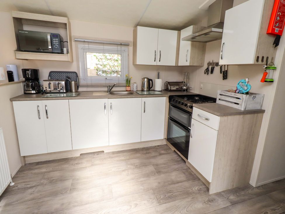 A kitchen with various appliances and cabinets at Gardeners Lodge 