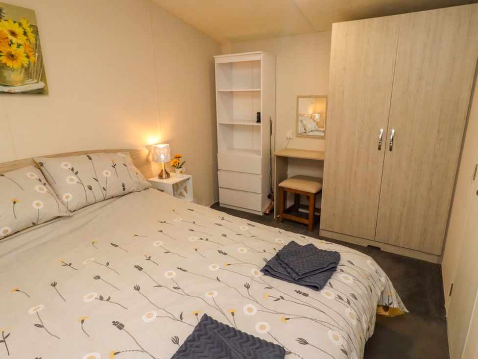 A bedroom with a bed and wardrobe at Gardeners Lodge in 